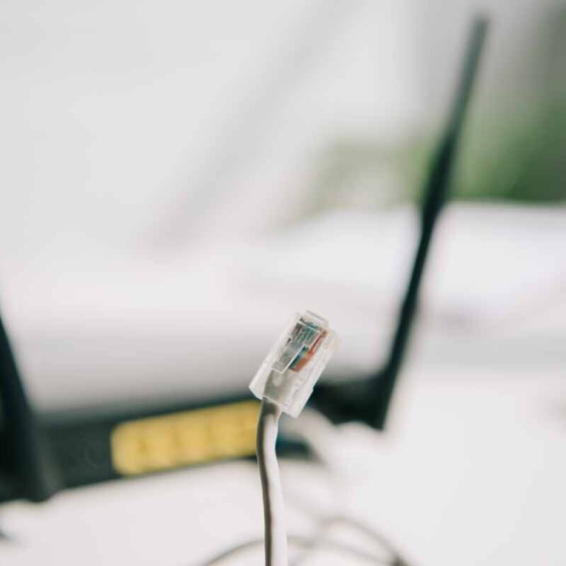 Close-up of an exposed Wi-Fi router and network cable in an unsecured indoor environment