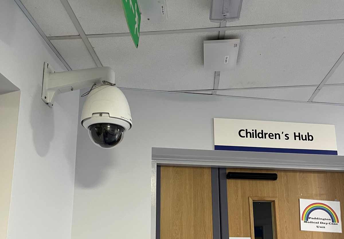 ngineer installing a protective CCTV camera cover to help prevent CCTV camera damage in a public building