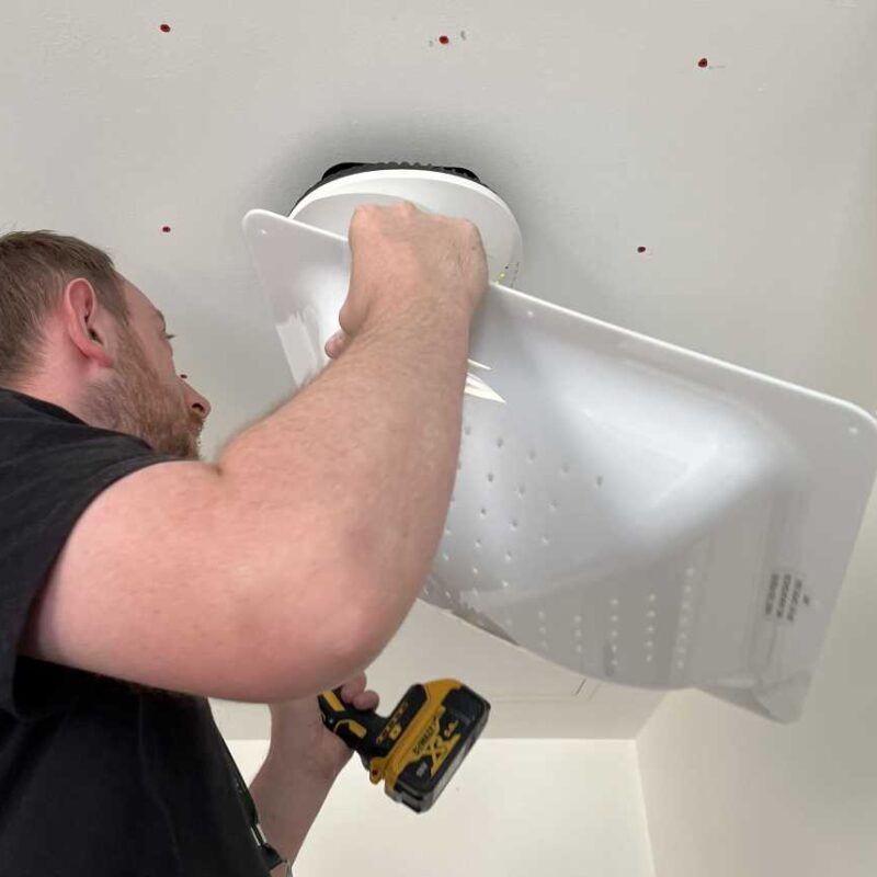 Engineer installing a protective enclosure around a Wi-Fi access point